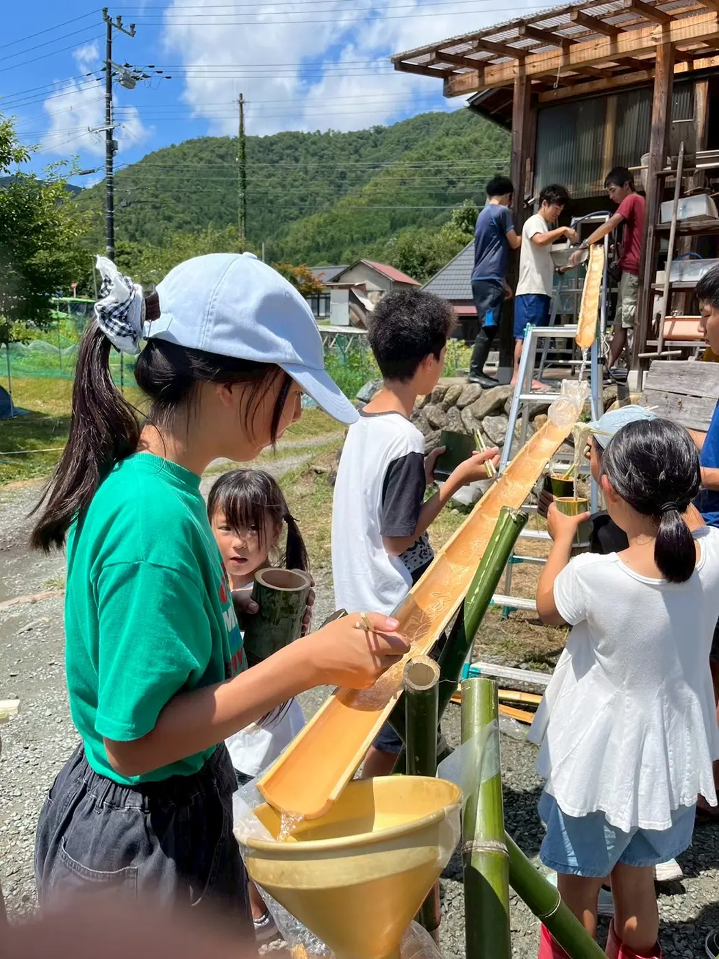 竹を組んでつくった流しそうめんの装置と子どもたち